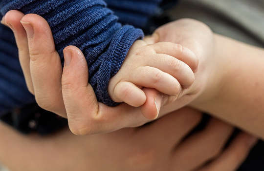 Today's Inspiration: December 29. 2022 a toddler's hand resting in an adult's hand