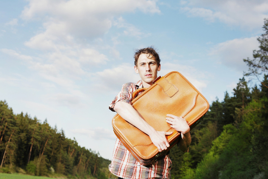 How to Stop Worrying about Stuff man standing outside clutching a suitcase to his chest