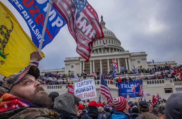 How Fear-Based Propaganda Shapes Society A crowd of protesters gathered outside the U.S. Capitol building, waving flags and holding signs supporting Donald Trump, during a political rally.